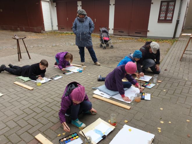 Vollkonzentrierte kleine Künstler auf dem Atelierhof